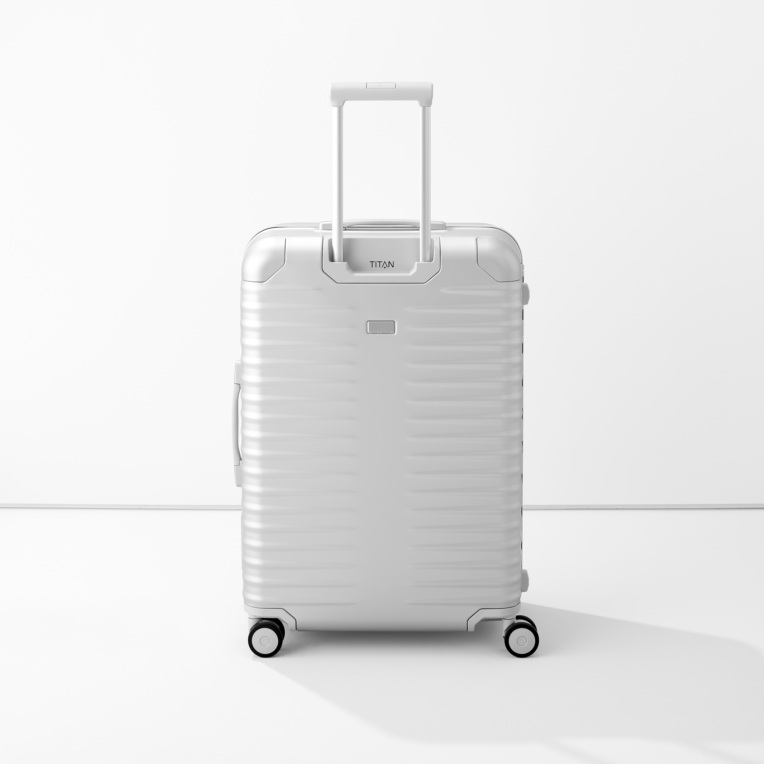 Moderner silberner Aluminium-Koffer mit vier Rollen und Teleskopgriff Hochwertiger, silberner Aluminium-Koffer mit Teleskopgriff und vier Rollen, steht vor weißem Hintergrund