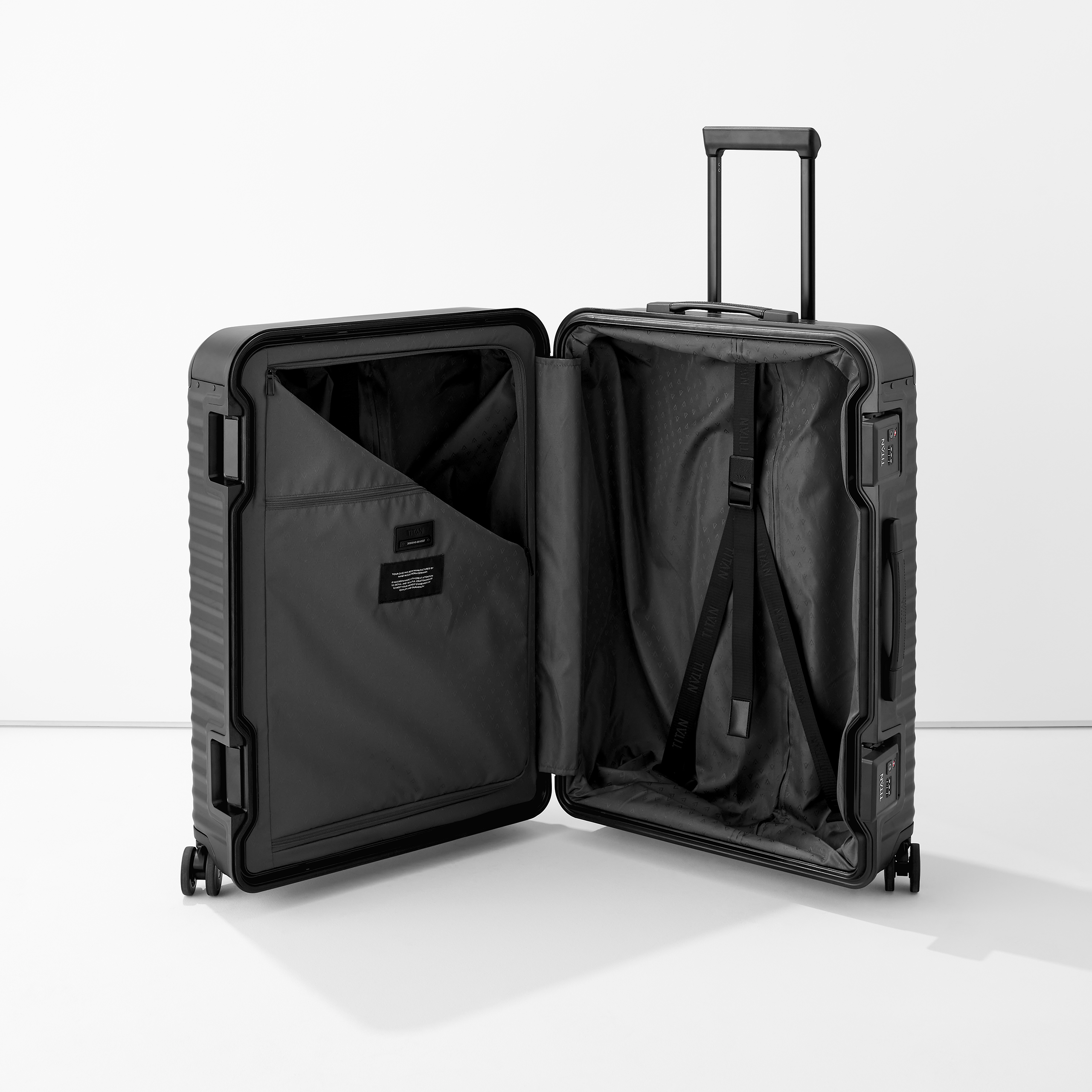 Valise noire à coque dure ouverte avec poignée télescopique et intérieur bien agencé, vue sur les sangles de compression et les compartiments intérieurs