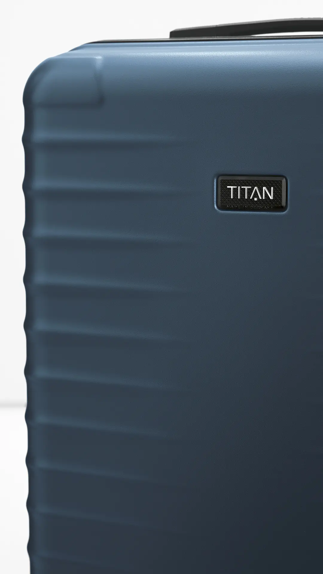Moderner, blauer Hartschalenkoffer von TITAN – robustes Reisegepäck, Made in Germany Detailansicht eines blauen Hartschalenkoffers von TITAN mit sichtbarem Logo, geeignet als Reisegepäck