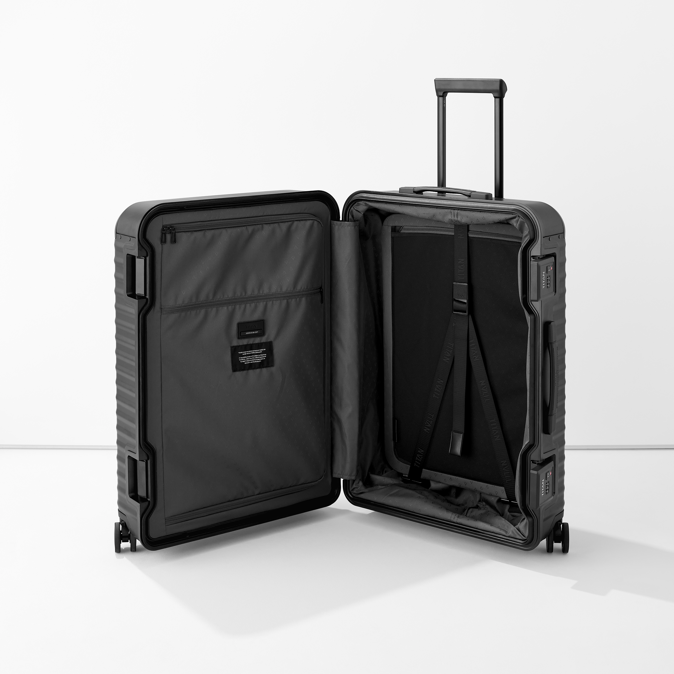 Valise rigide noire ouverte avec roulettes, poignée télescopique et compartiment intérieur spacieux et bien organisé