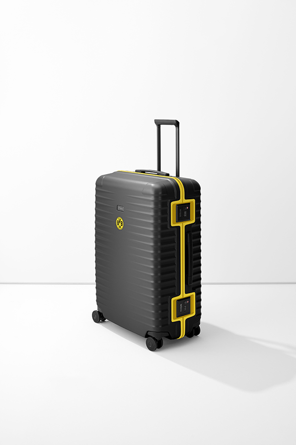 Black trolley L from TITAN with yellow accents. The case has a telescopic handle, four wheels and two TSA locks with Titan lettering. The BVB logo can be seen on the front. The surface of the trolley is ribbed.