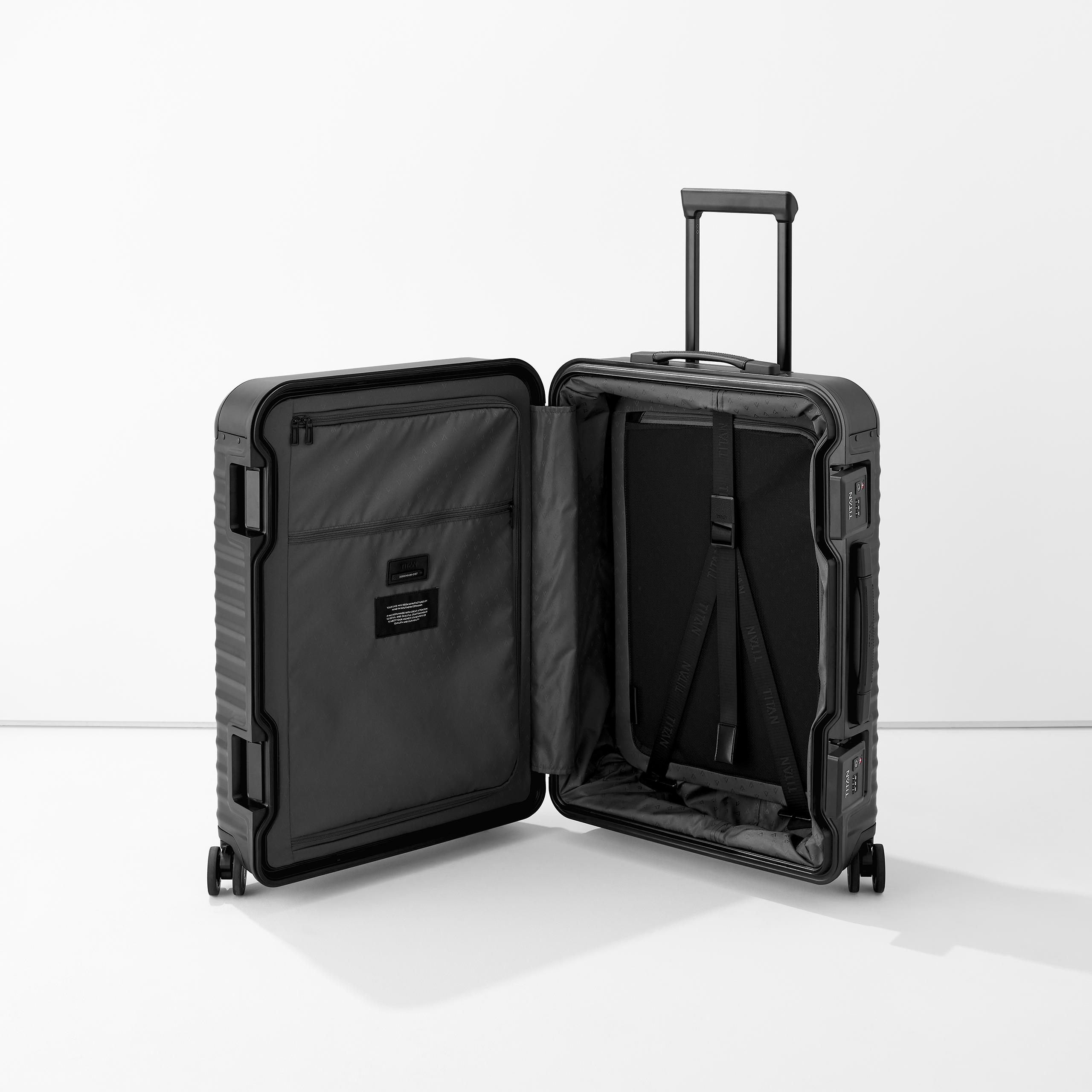 Offener schwarzer Hartschalenkoffer mit Innenfächern, Packgurten und ausziehbarem Griff auf weißem Hintergrund