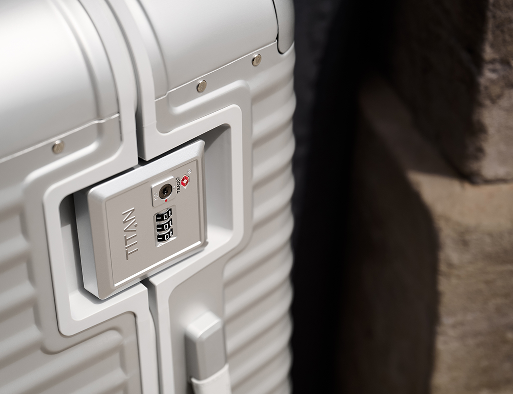 Nahaufnahme eines silbernen Aluminium-Koffers mit integriertem TSA-Zahlenschloss der Marke TITAN