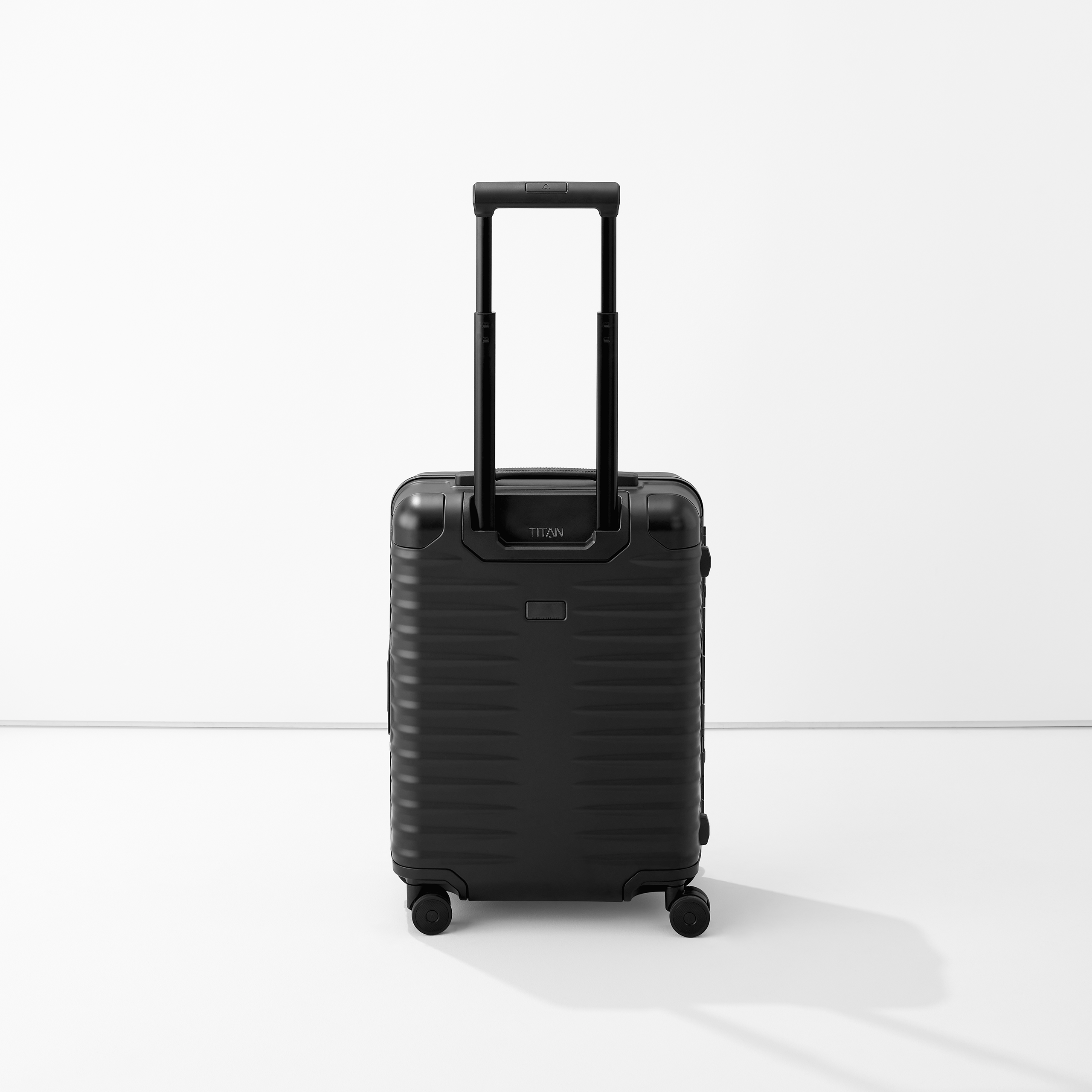 Schwarzer Hartschalenkoffer mit ausgezogenem Teleskopgriff und vier Rollen auf weißem Hintergrund