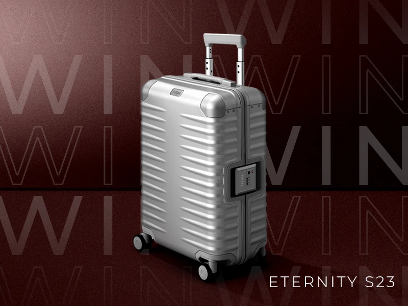 Silberner Rollkoffer mit Teleskopgriff und Zahlenschloss vor einem weinroten Hintergrund mit dem Wort "WIN" in großen, transparenten Buchstaben wiederholt. Der Koffer hat horizontale Rillen. Unter dem Koffer steht der Text "Eternity S23".