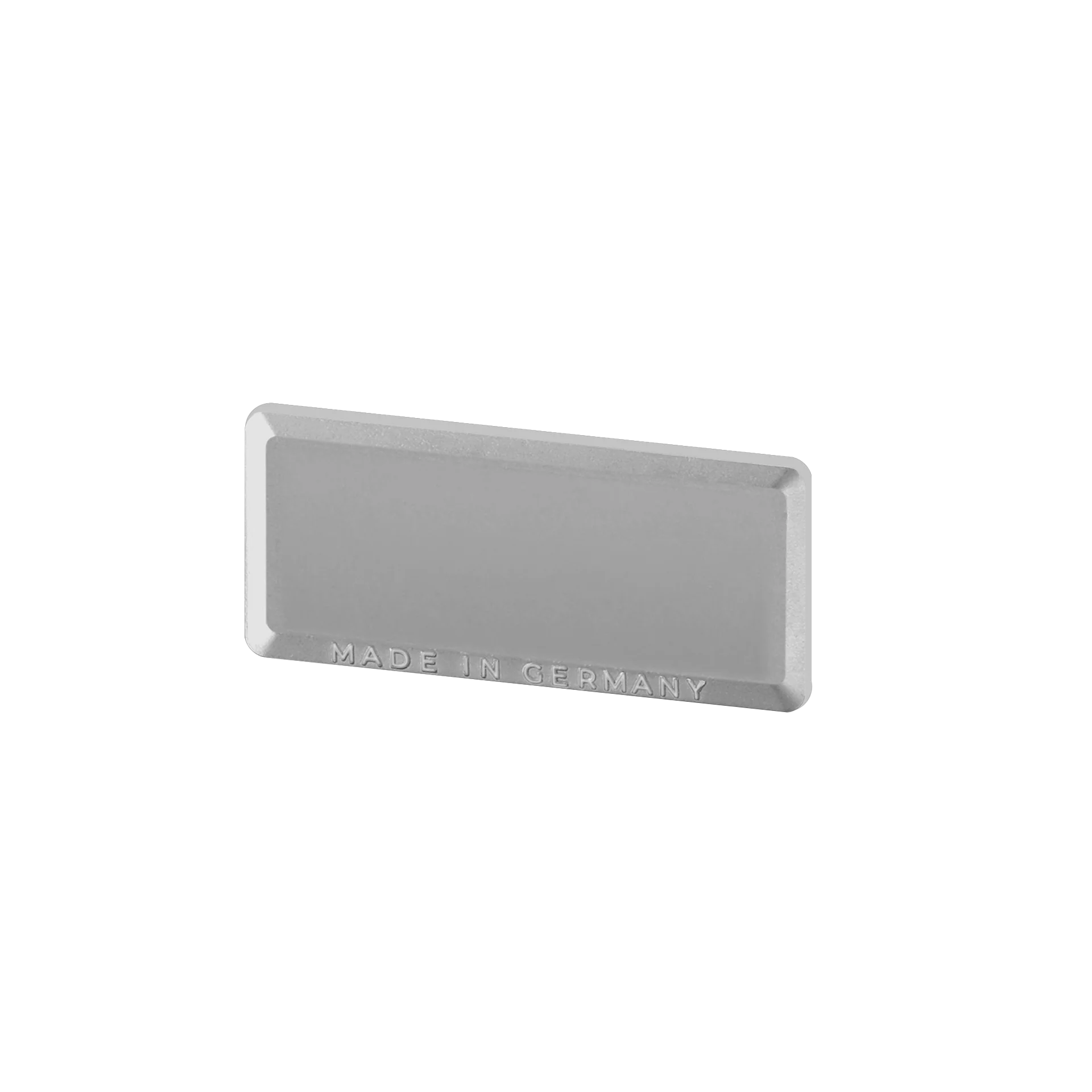 La imagen muestra una barra rectangular de metal plateado con esquinas redondeadas. La inscripción "MADE IN GERMANY" está grabada en la moldura. La superficie de la moldura es mate y refleja ligeramente la luz.