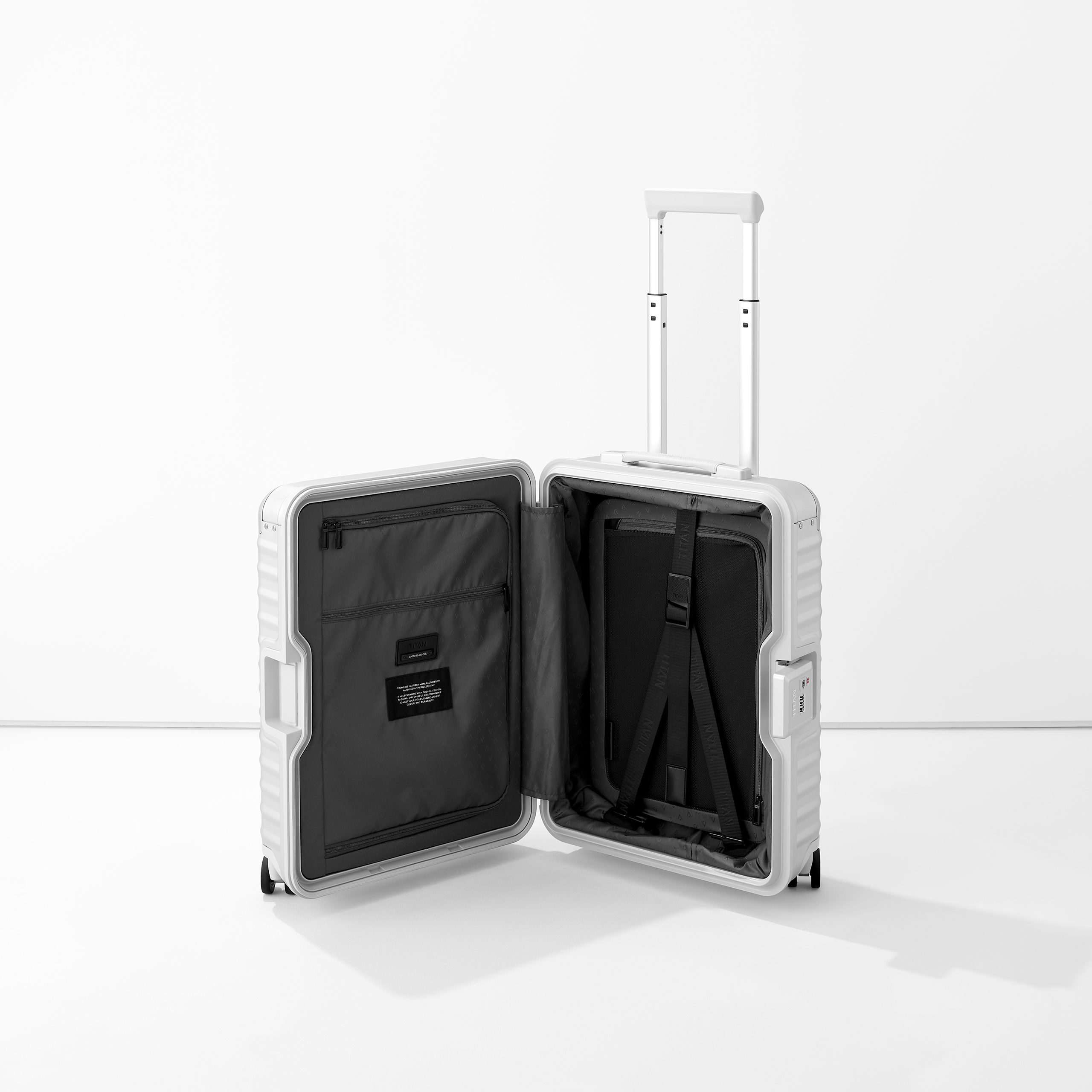 Geöffneter moderner Aluminium-Koffer mit ausziehbarem Griff und organisiertem Innenleben Weißer Trolley aus Hartschale, geöffnet, mit Innenfächern und einem ausziehbaren Griff, auf weißem Hintergrund