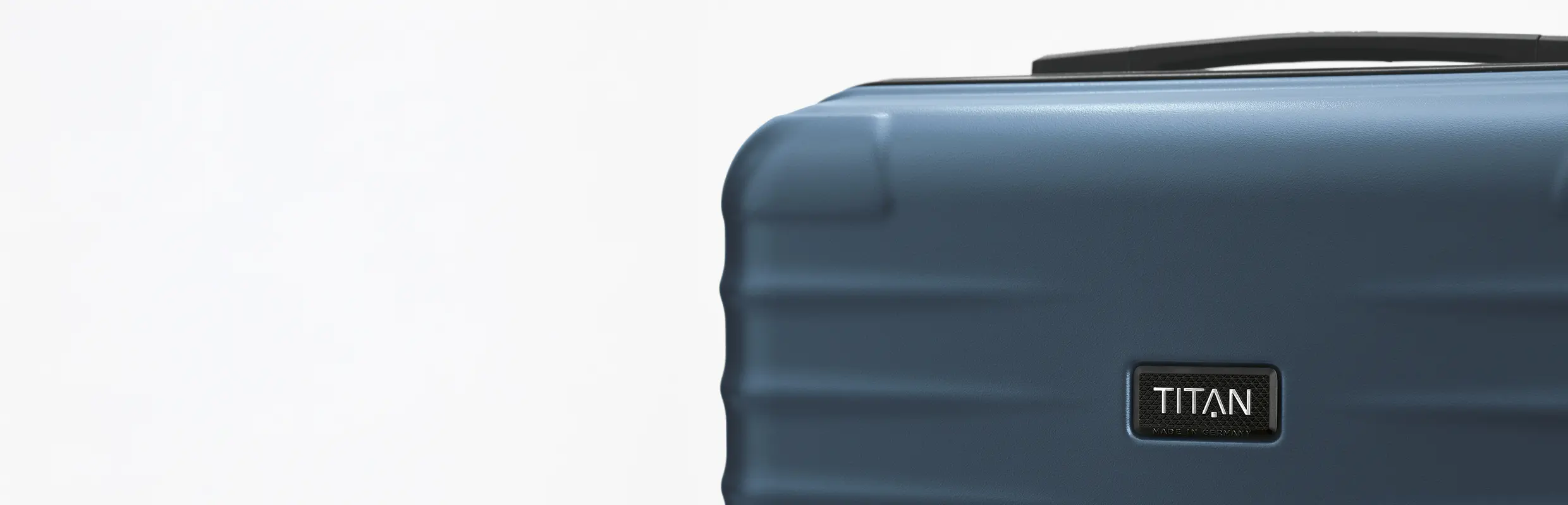 Detailansicht eines blauen Hartschalenkoffers von TITAN Nahaufnahme eines blauen Koffers der Marke TITAN mit sichtbarem Logo auf weißem Hintergrund
