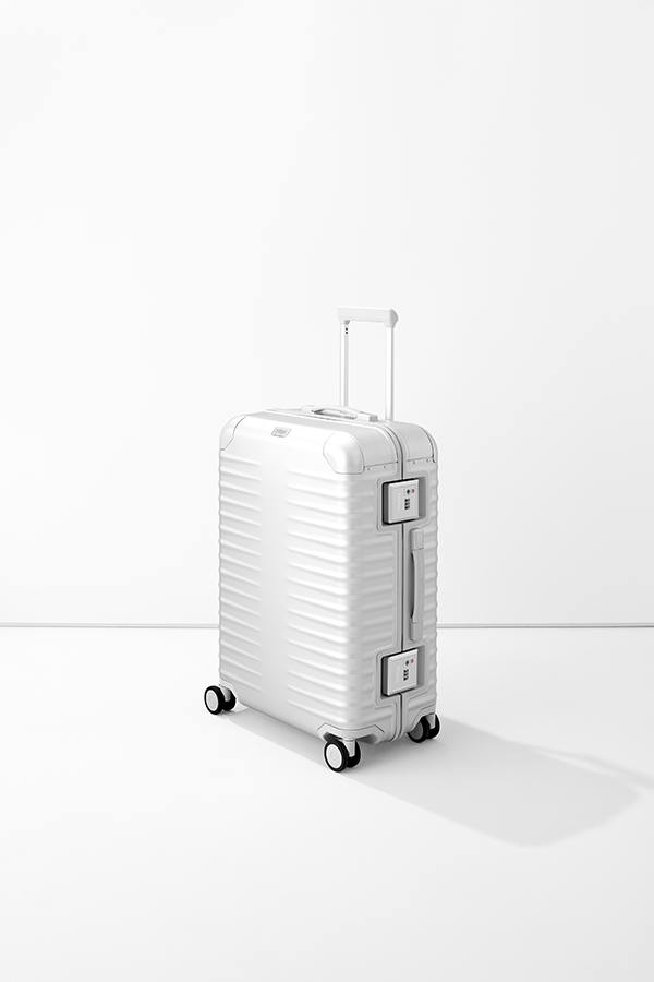 Moderner Aluminium-Koffer in Silber mit TSA-Schloss und vier Rollen Weißer Aluminium-Koffer mit Rillenstruktur, Teleskopgriff und TSA-Schlössern auf vier Rollen, freigestellt vor weißem Hintergrund