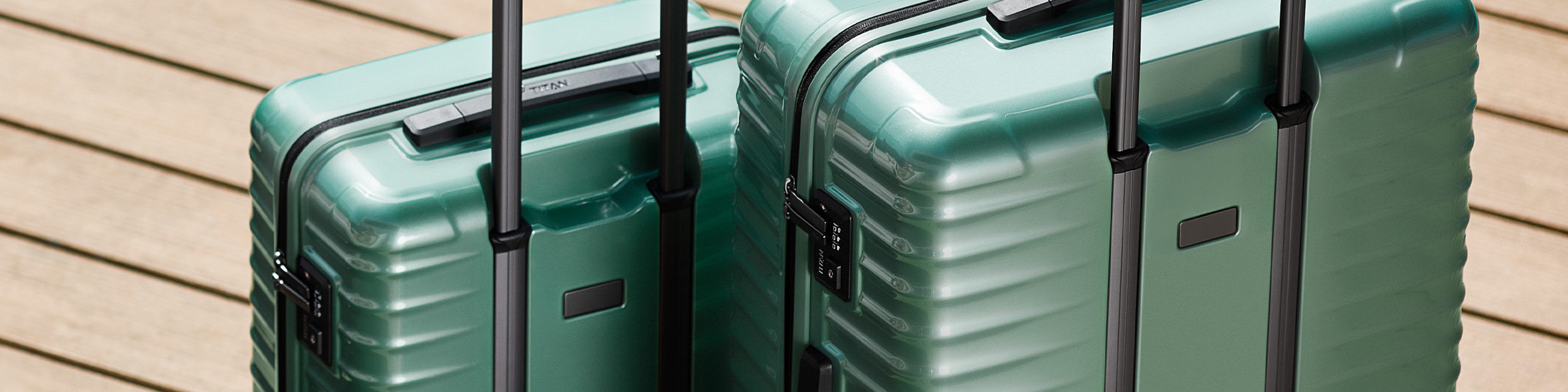 Due custodie rigide verdi con manico telescopico su una base di legno