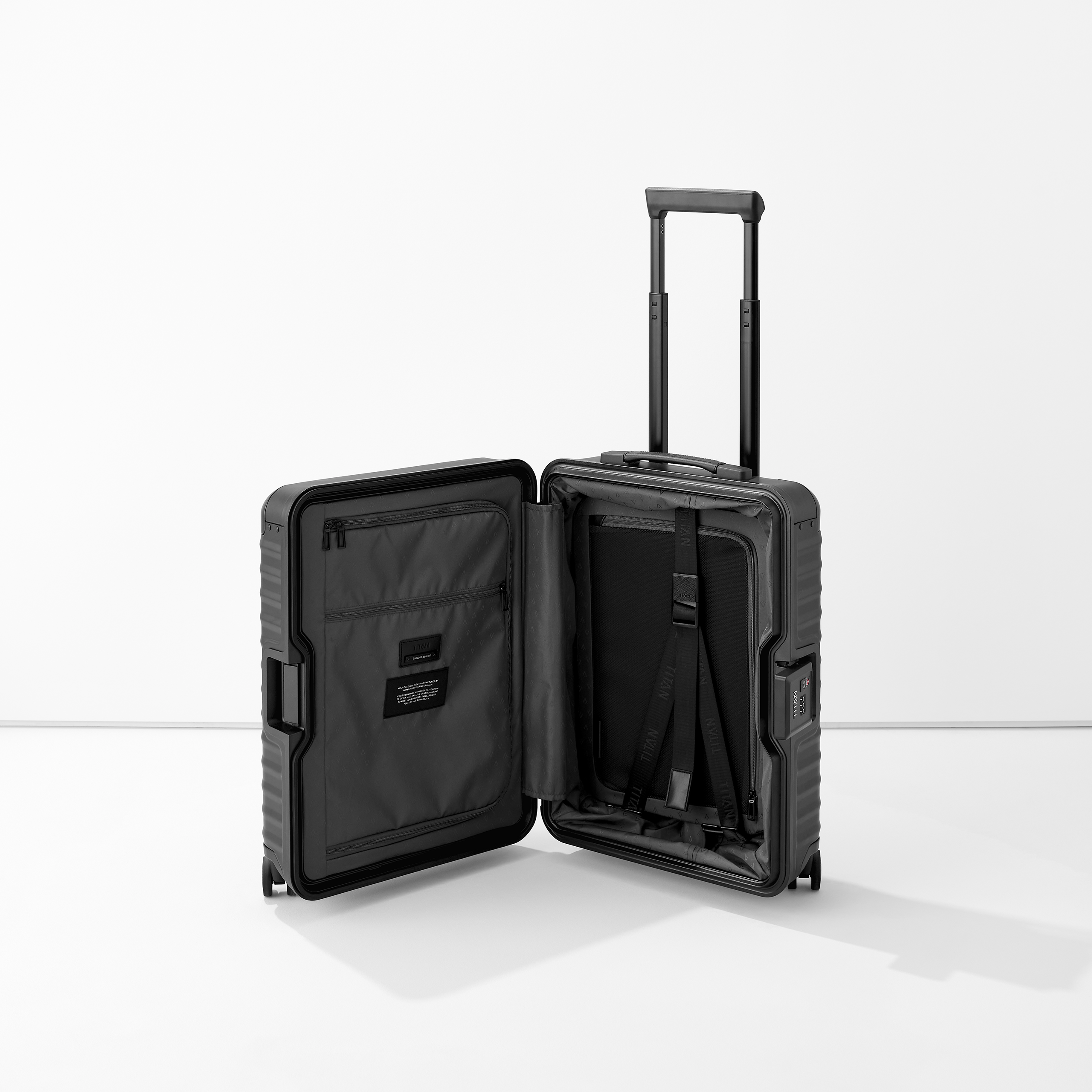 Geöffneter schwarzer Kabinenkoffer mit Teleskopgriff, Innenfächern und Gepäckgurten auf weißem Hintergrund