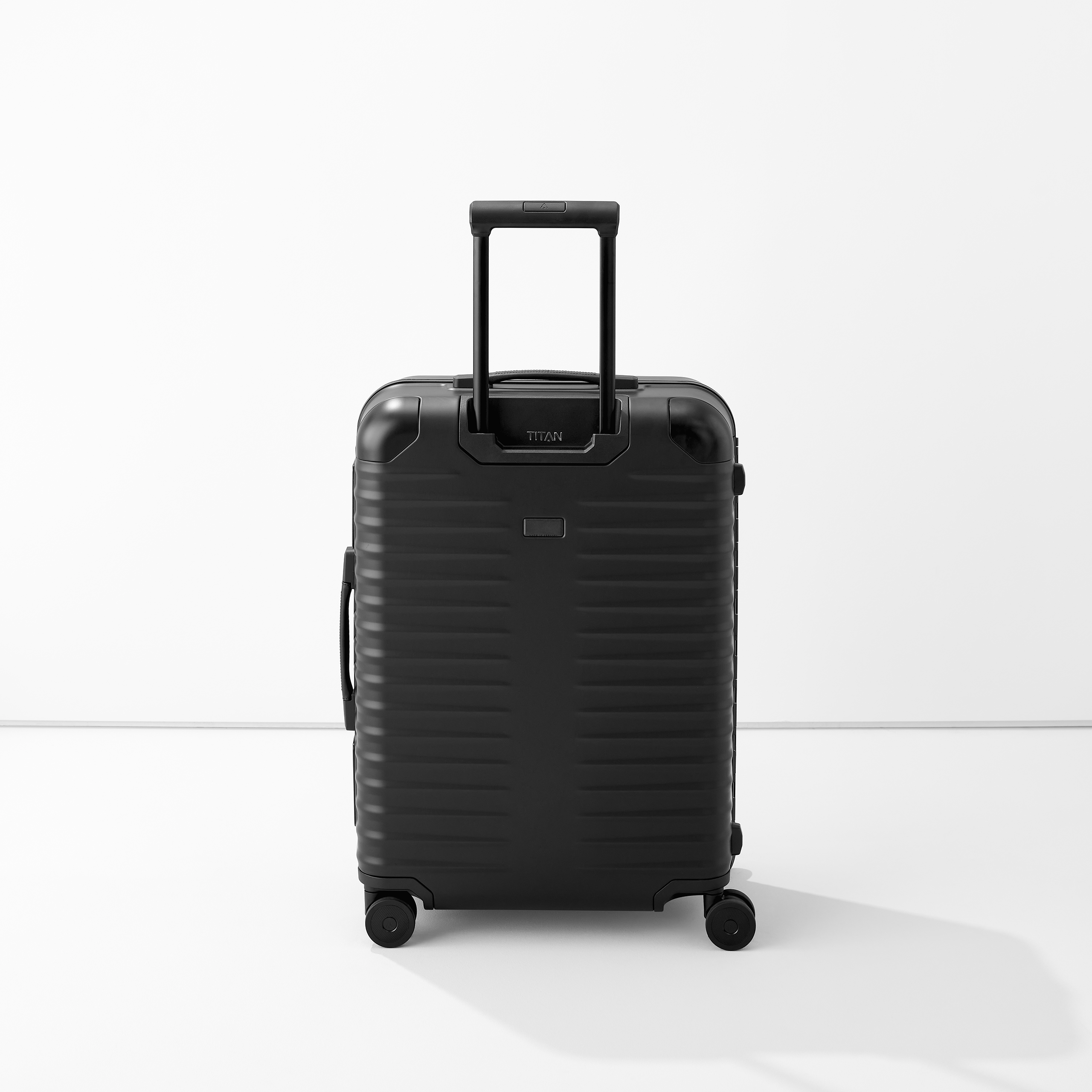 Moderner Hartschalen-Koffer in Schwarz mit Teleskopgriff und vier Rollen, freigestellt vor weißem Hintergrund